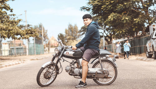 Man riding bicycle on road in city