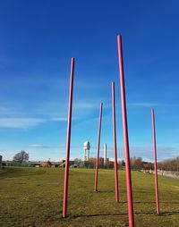 Metallic structure on field against blue sky