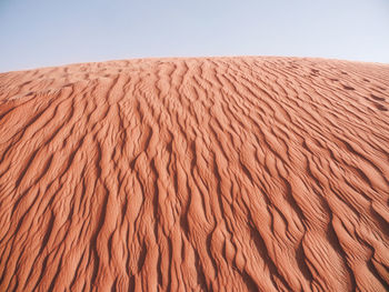 Scenic view of sand dunes against clear sky