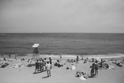 People enjoying at beach against sky