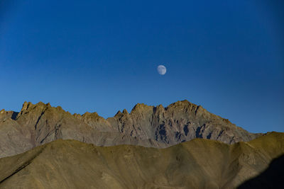 Scenic view of mountains against clear blue sky