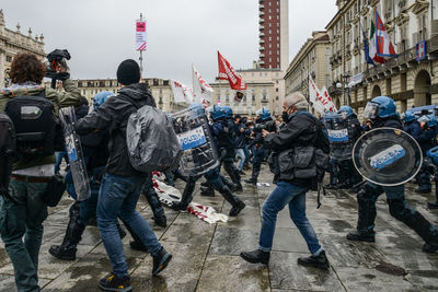 People on street against buildings in city