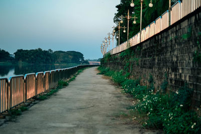 Footpath amidst buildings against clear sky