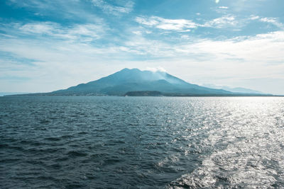 Scenic view of sea by mountains against sky