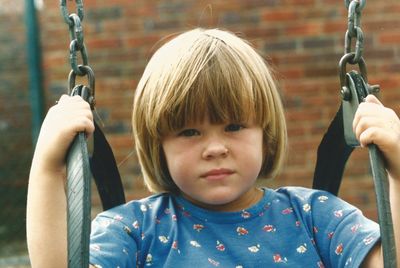 Close-up of boy on swing