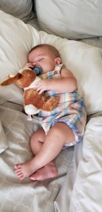 High angle view of baby sleeping on bed