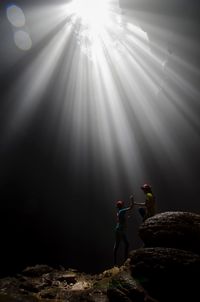 People standing by rocks at night