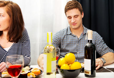 Young man and woman sitting on table