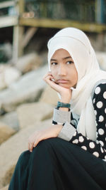 Portrait of smiling young woman sitting outdoors