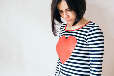 Woman with heart shape on t-shirt against white background