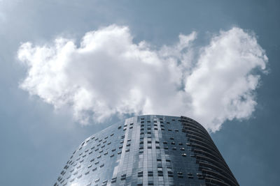 Low angle view of modern building against clouds in the sky