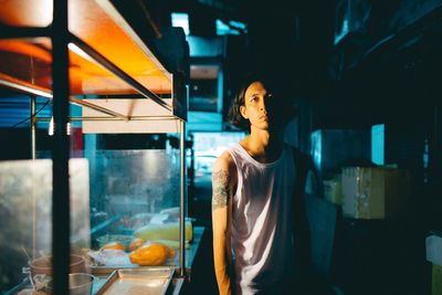 Portrait of male vendor standing at night