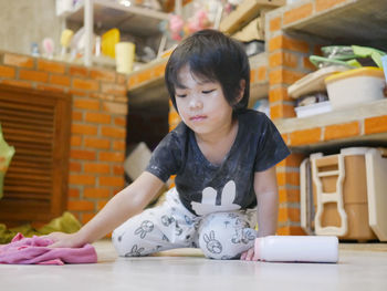 Cute girl cleaning floor at home