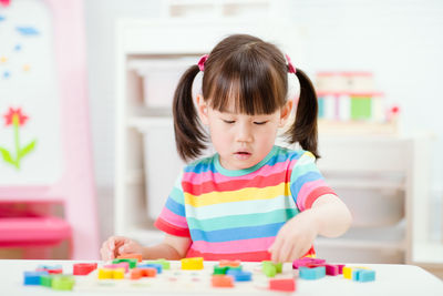 Young girl learning letter blocks for homeschooling