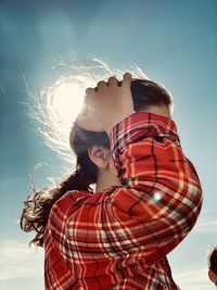 Low angle view of woman standing against sky