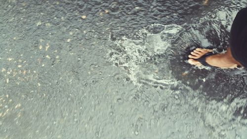 Low section of woman relaxing on wet sand