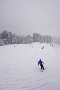 People skiing on snow covered field