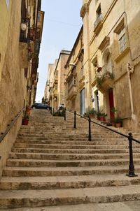 Low angle view of steps amidst buildings in town