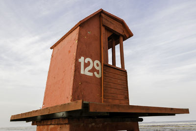 Low angle view of lifeguard hut at beach against sky