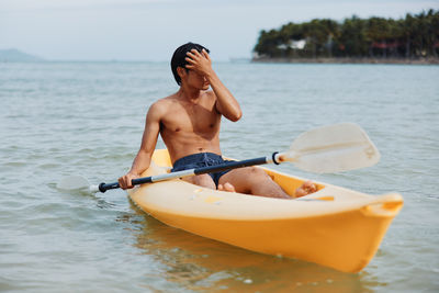 Portrait of shirtless man swimming in sea