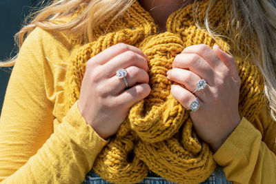 Midsection of woman holding yellow scarf