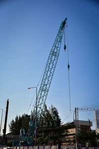 Low angle view of crane against blue sky