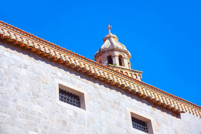 Turret and tiles of the old fort . white wall and windows with grates