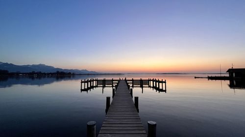 Pier over sea against clear sky during sunset