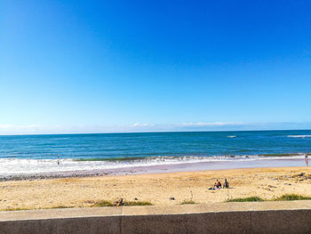 Scenic view of beach against clear blue sky