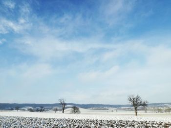 Scenic view of snowy field against sky