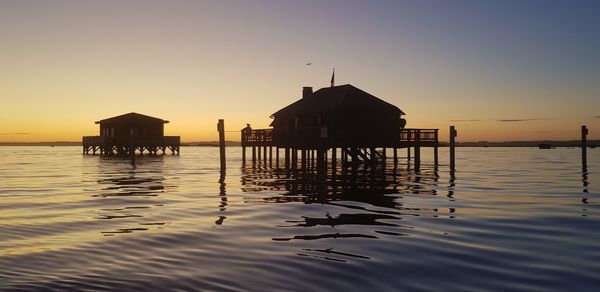 Scenic view of sea and buildings against sky during sunset