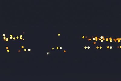 Illuminated lights against sky at night