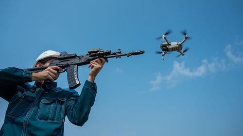 Low angle view of man standing against clear sky