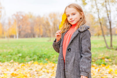 Portrait of young woman standing on field