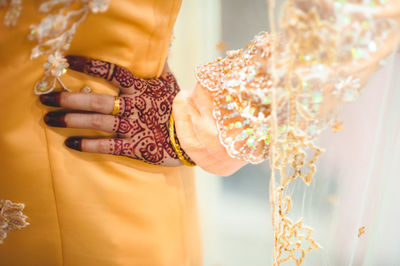 Midsection of bride standing with hand on hip