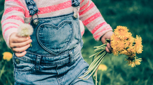 Midsection of girl holding flowers