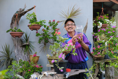 Woman standing by potted plants