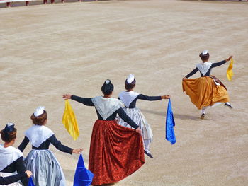 Rear view of people walking on land