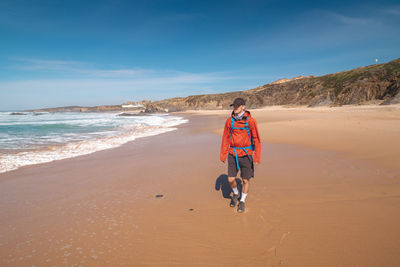 Rear view of people walking at beach