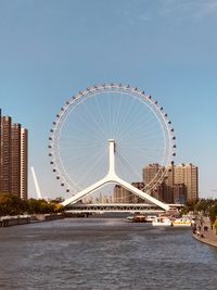 Ferris wheel in city against clear sky