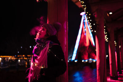 Side view of woman looking away at night