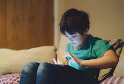 Cute boy using digital tablet at home