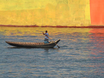 Man in boat on sea against sky