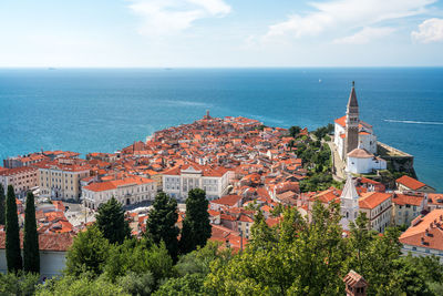 High angle view of townscape by sea against sky