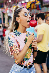 Cheerful lady having fun enjoying sweet candy apple