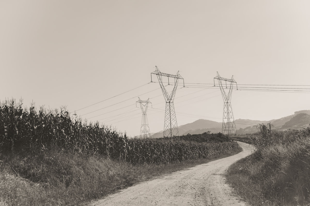 ELECTRICITY PYLON ON ROAD AGAINST SKY