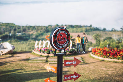 Information sign on field against sky