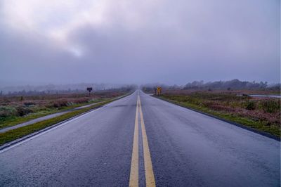 Empty road along countryside landscape