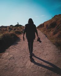Rear view of man and woman walking on mountain