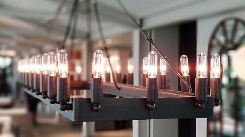 Close-up of illuminated lighting equipment hanging in building